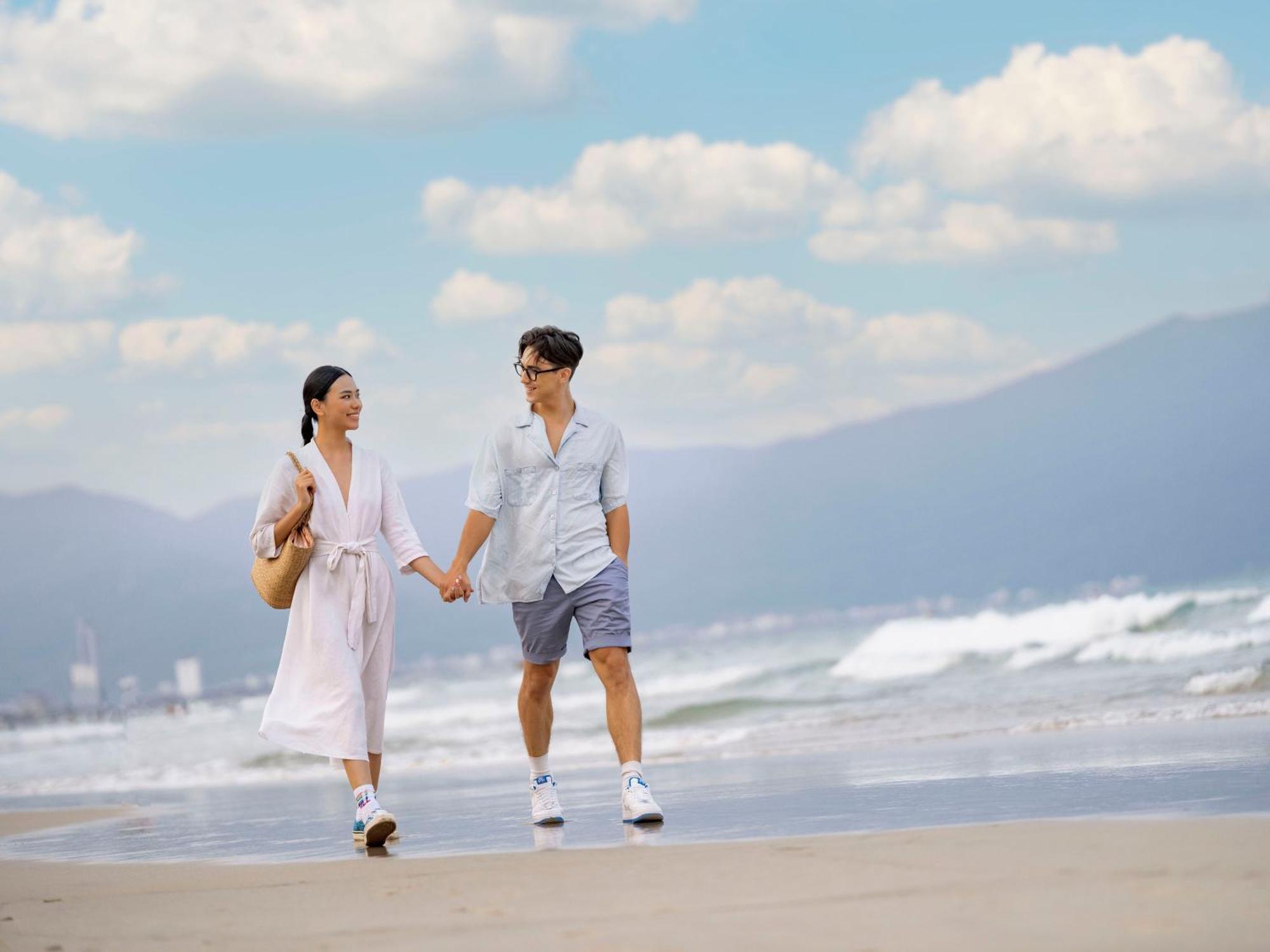 Dlg Hotel Danang Exterior foto A couple walking on the beach